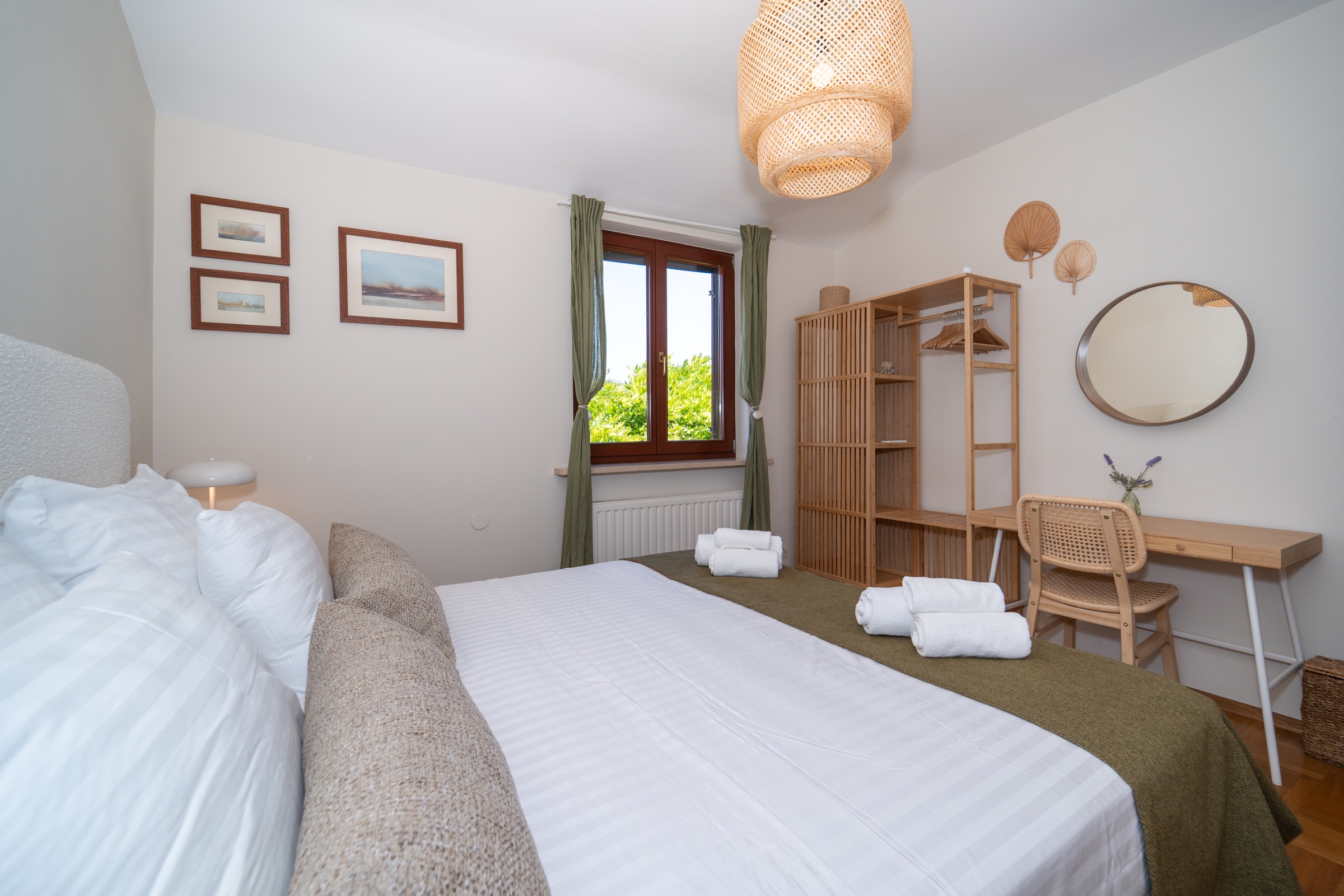 First green double bedroom with olive textiles, a writing desk and natural woven details