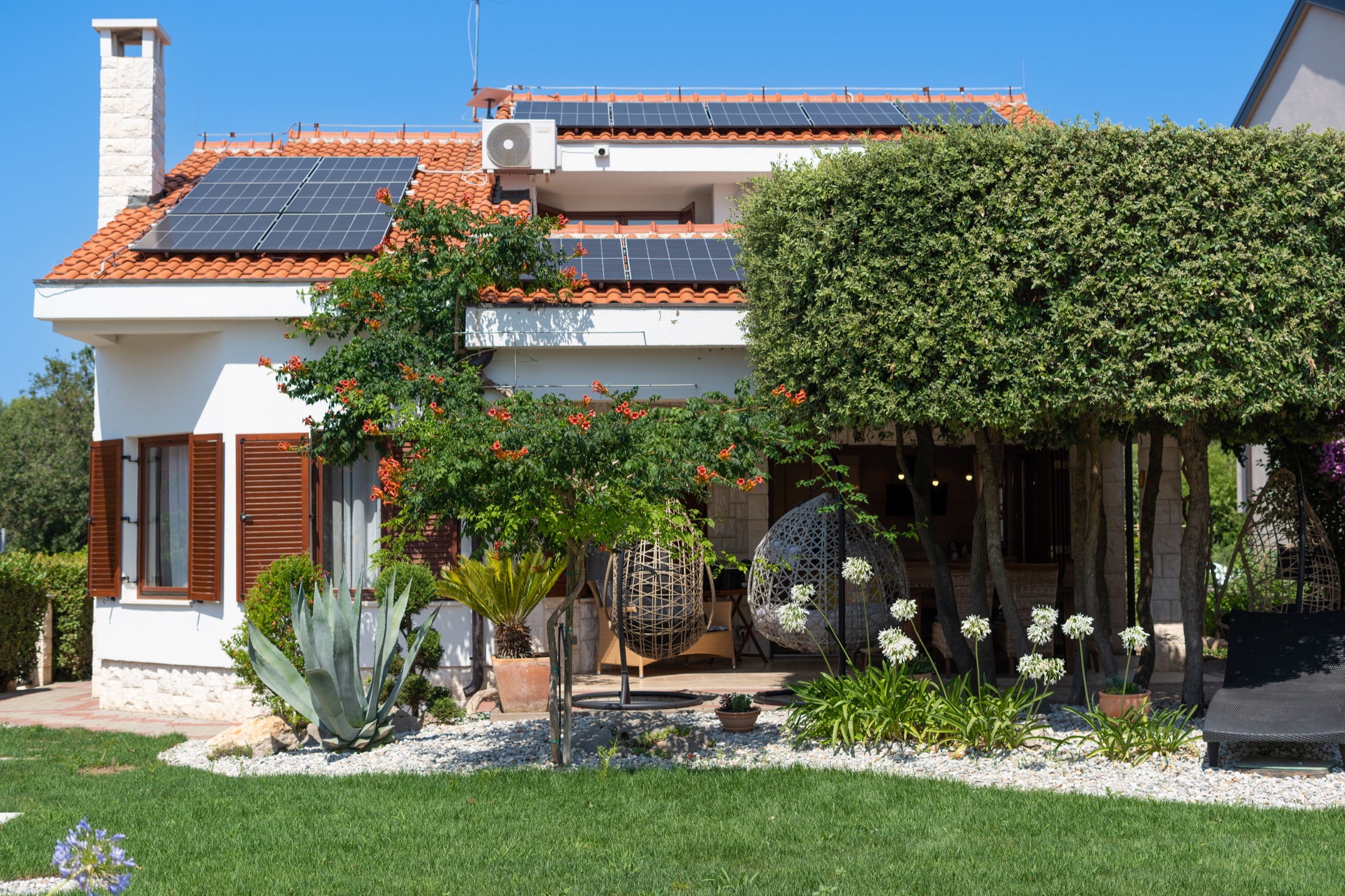 Villa Lostura framed by its mature Mediterranean garden