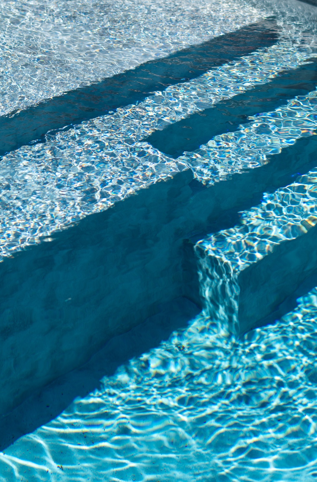 Sunlight moving across the pool steps